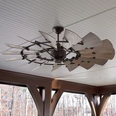 a ceiling fan is hanging from the ceiling in a room with wood beams and white walls