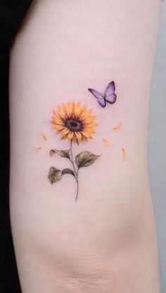 a small sunflower and butterfly tattoo on the side of a woman's thigh