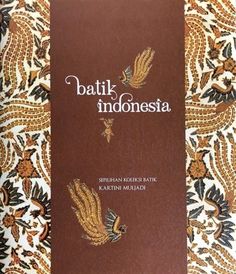 the book bali indonesia is sitting on top of a tablecloth covered bed spread with an intricate pattern