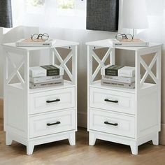 two white nightstands with books on top of them