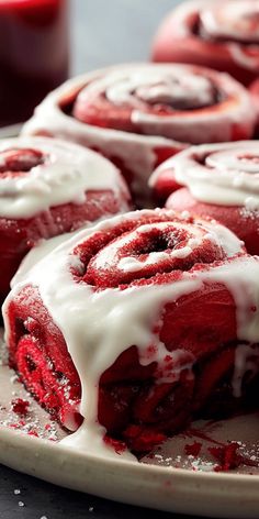 red velvet rolls with white icing on a plate