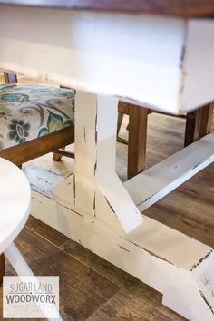 a white table with two chairs next to it and a bench in the back ground