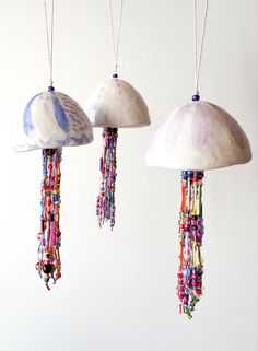 three lamps hanging from strings with beads on them