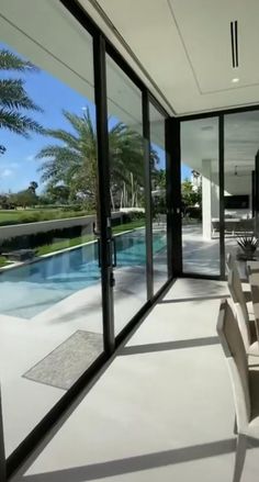 a dining room table sitting next to a swimming pool in the middle of a house