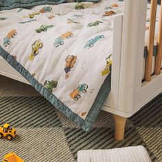 a toddler's bed with cars and trucks on it, next to a toy truck