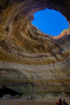 people are standing in the middle of a cave with a blue sky behind them and there is no image to describe