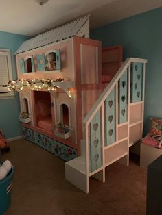 a child's bedroom with a bunk bed and stairs to the second floor is decorated in pastel colors