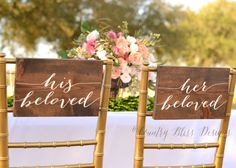 two wooden signs that say his beloved and her beloved are sitting next to each other