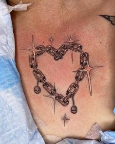 a heart shaped tattoo with chains and stars