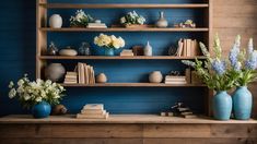 two vases with flowers are sitting on a shelf in front of bookshelves