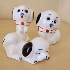 three ceramic dogs sitting on top of a wooden table