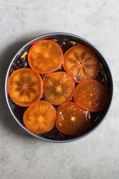 a bowl filled with sliced oranges on top of a table