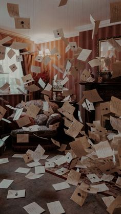 a room filled with lots of papers flying in the air and on top of a bed