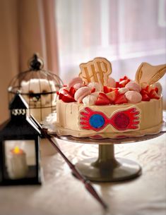 a decorated cake sitting on top of a table next to a candle and lantern holder