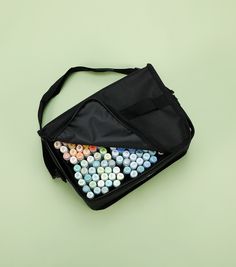 a black bag filled with lots of different colored candies on top of a green surface