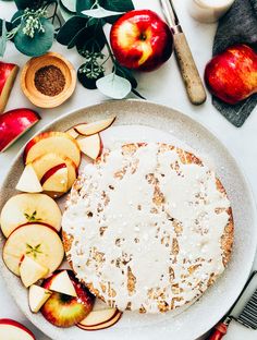 an apple pie on a plate with sliced apples