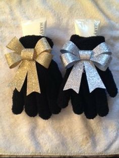 two black and white mittens with silver bows on them sitting next to each other