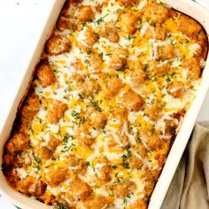 a casserole dish with meat and cheese in it on a white tablecloth