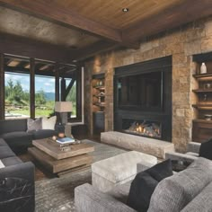 a living room filled with furniture and a fire place next to a large glass window