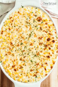 a casserole dish with cheese and herbs in it on a wooden table top