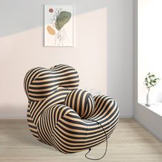 two black and white striped chairs sitting in front of a window next to a potted plant