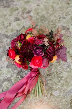 a bouquet of flowers sitting on top of a stone floor next to a color swatch