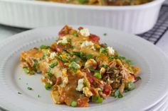 a white plate topped with food next to a casserole dish