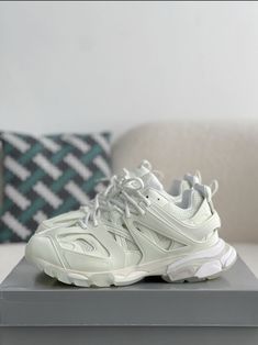 Embrace a futuristic aesthetic with these Track-inspired sneakers, capturing the essence of Balenciaga's iconic design. The clean, all-white colorway creates a minimalist yet bold statement. The multi-layered upper, crafted with a mix of mesh and synthetic materials, provides a dynamic look and breathable comfort. The chunky sole adds a modern edge, while subtle Balenciaga branding details complete the look. Balenciaga Track 2, Shoes 2021, White Platform Sneakers, Platform Trainers, All Black Shoes, Sport Shoes Fashion, Women Platform Shoes, Balenciaga Track, Dad Shoes