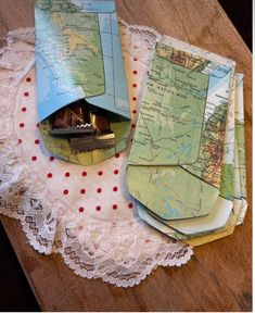 several folded maps on a doily with red dots