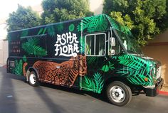 the food truck is decorated with green leaves and an image of a tiger on it's side