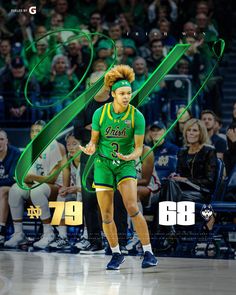 the basketball player is running on the court with green streamers in her hair and headbands