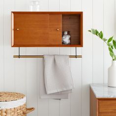 a wooden cabinet with towels hanging from it