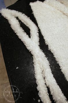 a black and white table topped with a knife and fork covered in fluffy white stuff