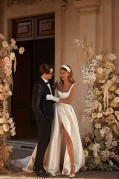 a man in a tuxedo and a woman in a wedding dress standing next to each other