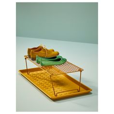 three pairs of shoes are sitting on a drying rack