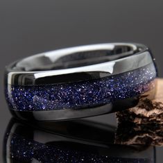 "Blue Goldstone Ring with \"Starry Night\" appearance. Made with Black ceramic band. It has a strong presence and the sandstone has the appearance of looking deep into space or the night. Great gift for men or women! Very cool wedding band or promise ring! Why buy from us? We do our best to make the ring buying process simple and easy for you. With this ring we include: ** Made With Love ** ** Many great 5 star reviews ** ** FREE 1 Year Limited Warranty (See FAQ) ** ** A portion of the sale goes to support charity ** Buy with confidence knowing we will do everything we can to make sure you're happy with the purchase :) // Ring Sizing And Returns // Please double check your ring size before ordering. Please also check if the sizing was done with a comfort fit or standard fit and that the ri Mens Band Ring, Men’s Promise Ring Aesthetic, Dark Blue Wedding Ring, Blue Wedding Rings Men, Space Gifts For Men, Space Wedding Ring, Star Wedding Ring, Mens Wedding Bands Blue, Avatar Ocs