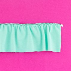 the top half of a skirt on a pink and green background with white stitching