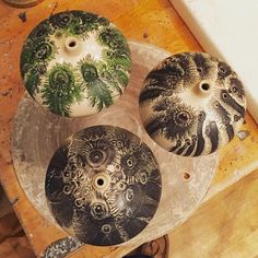 three decorative vases sitting on top of a wooden table