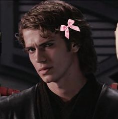 a young man with a pink bow in his hair