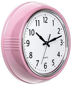 a pink wall clock with numbers on the face