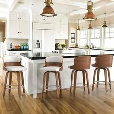 three stools sit at the center of a kitchen island