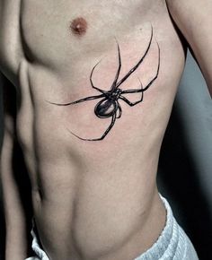 a black spider tattoo on the side of a man's chest, which is covered in an orb - like substance