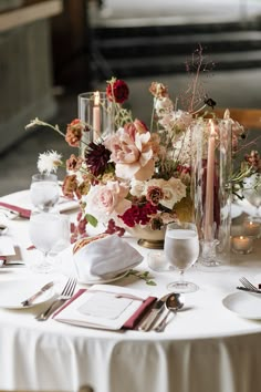 the table is set with flowers and candles