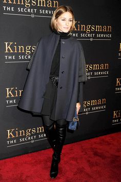 a woman standing on top of a red carpet next to a black wall with kingsman the secret service written on it