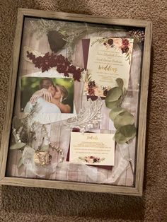 a wedding collage is displayed in a wooden frame with flowers and leaves on it