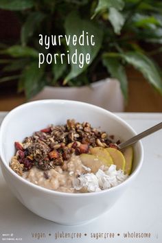 a white bowl filled with oatmeal and fruit on top of a table