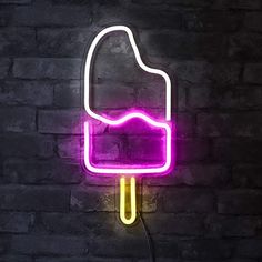 an ice cream neon sign is lit up on a brick wall with a black background