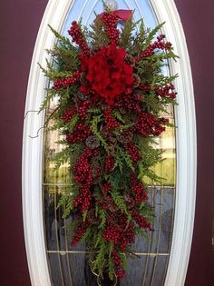 red flowers hanging from the side of a white door