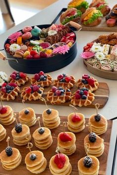 a table topped with lots of waffles covered in berries and other toppings