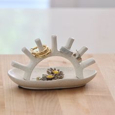 a white ceramic ring holder sitting on top of a wooden table